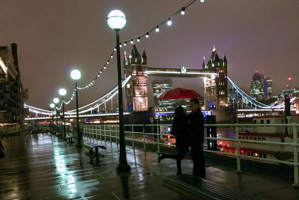 A romantic moment on Tower Bridge, with London glowing beautifully after dark.