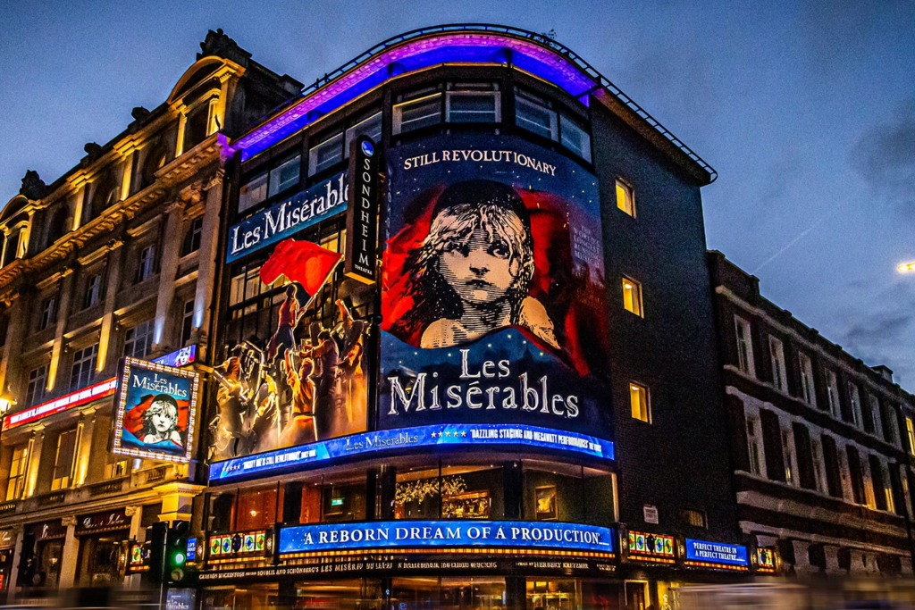 A West End theatre glowing at night as audiences gather for a world-class show.