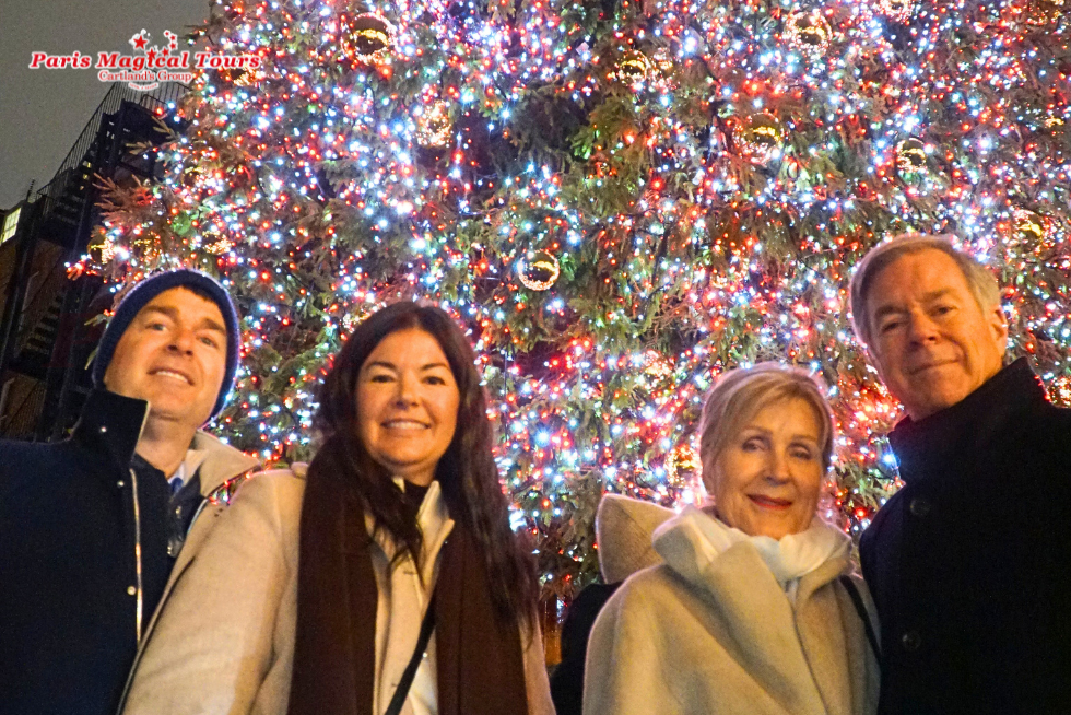 Enjoying a festive moment beside a beautifully decorated Christmas tree in Paris.